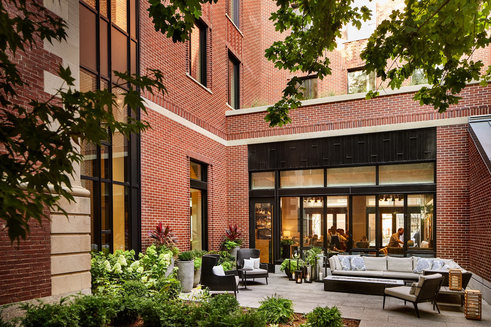 The Whitney Hotel courtyard on Charles Street, with brick facades, planters and outdoor seating